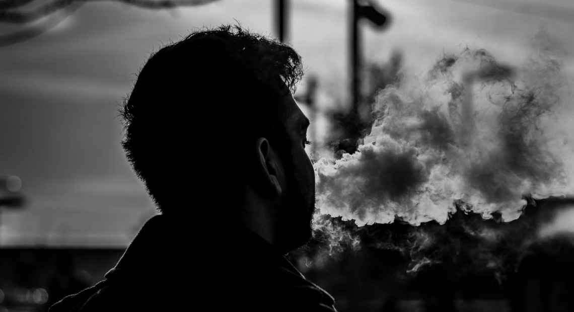 grayscale photography of man smoking