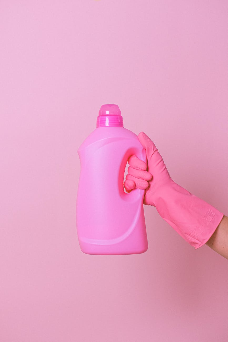 crop housekeeper with pink bottle of cleaner